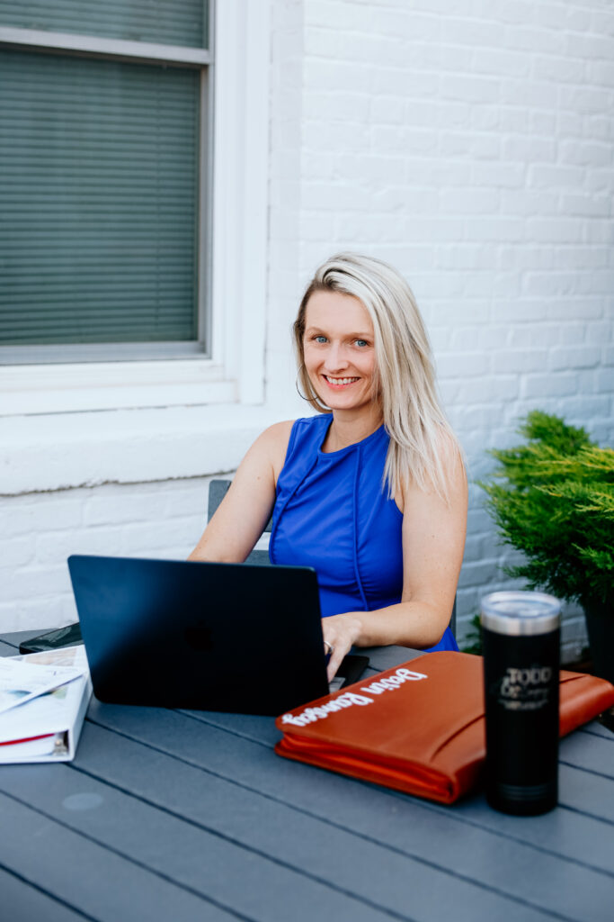 Woman working on laptop outdoors.
